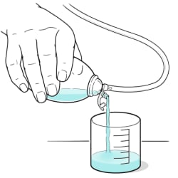 Fluid being poured from bulb into measuring cup.