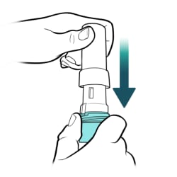One hand holding bottom of inhaler upright and other hand pushing cap back on.