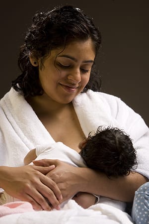 Female breastfeeding an infant.