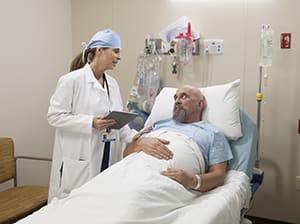 Doctor talking to patient in pre-op hospital room.
