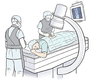 Healthcare provider giving injection in man's back. Man is lying face down on imaging table.