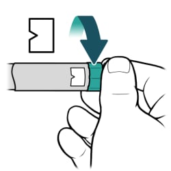 Hand turning dial on end of insulin pen to correct priming dose.