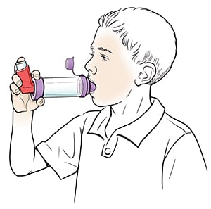 Boy using metered-dose inhaler with spacer.