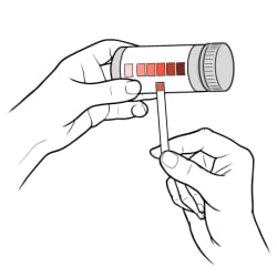 Hand holding ketone test strip up to color chart on test strip tube to find color match.