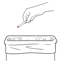Hand throwing ketone test strip into trash.