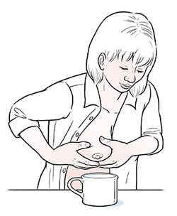 Une femme tirant le lait maternel à la main.