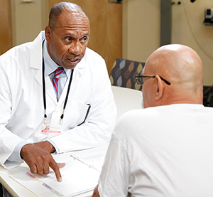 Lalakinng nakikipag-usap sa tagapangalaga ng kalusugan.