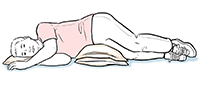 Person lying on side with pillows under head and hip.