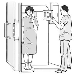 Patient in fluoroscopy scanner sipping liquid through straw while technologist prepares for scan.