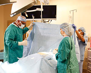 Doctors performing surgery in operating room.