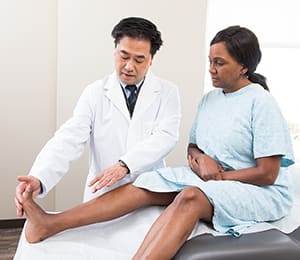 Doctor examining woman's foot.