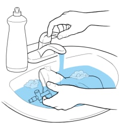 Hands washing catheter bag with soap under faucet with running water.