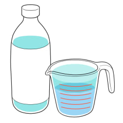 Bottle of cleaning solution next to measuring cup of water.