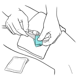 One hand holding catheter and other hand using alcohol wipe to clean catheter tip.