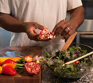 Person making salad in kitchen.